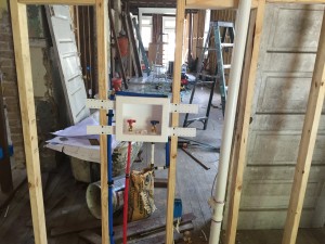 Inside the laundry looking toward the kitchen. Plumbing rough in for the washing machine.